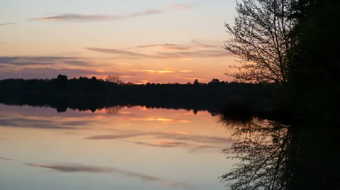 Sunrise time lapse over the still waters of a lake - 1080p 30fps Stock Footage 38769356
