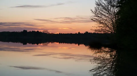 Sunrise time lapse over the still waters of a lake - 1080p 24fps Stock Footage 38769370