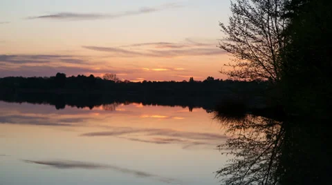Sunrise time lapse over the still waters of a lake - 1080p 25fps Stock Footage 38774374