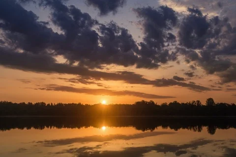 Sunrise timelapse over a calm river with thick clouds above Stock Footage 109581295