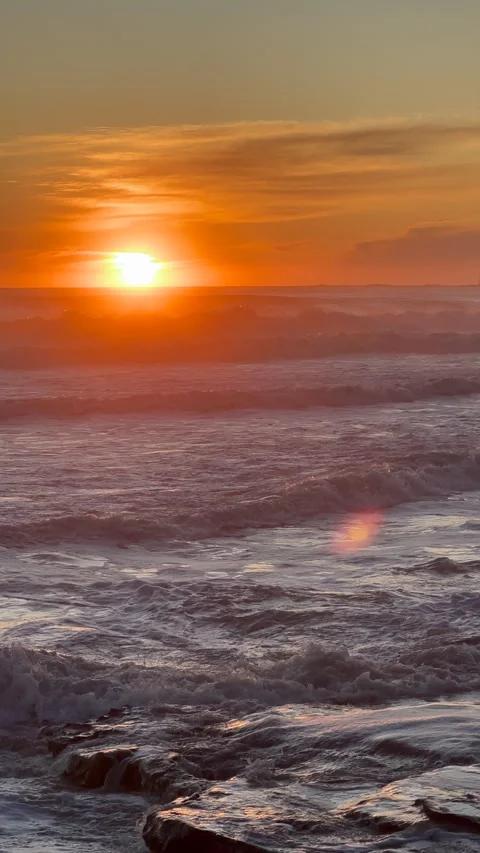 Sunrise With Waves Breaking Over Rocky Shoreline and Sun Flare Vidéo 301661344