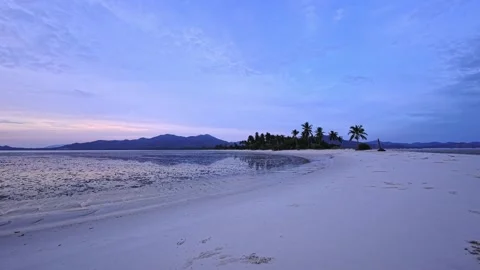 Sunrise on a white sand beach at low tide on a tropical island with palm trees Stock Footage 329417684