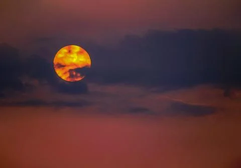 Sun's disk in dramatic red, orange and burgundy colors against the backgrou.. Stock Photos