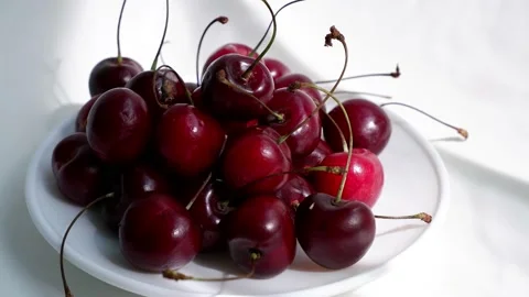 The sun's rays are falling on a plate with cherries. Stock Footage 157555788
