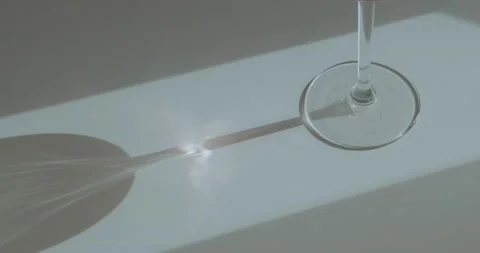 The sun's rays are refracted through a wine glass Stock Footage 186722501