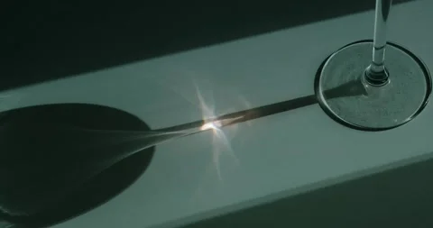 The sun's rays are refracted through a wine glass Stock Footage 186722531