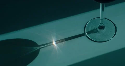 The sun's rays are refracted through a wine glass Stock Footage 186723942