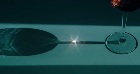 The sun's rays are refracted through a wine glass Stock Footage 186724425