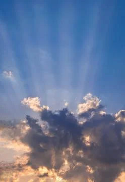 Suns rays beaming from behind  summer evening cloudscape Stock Photos