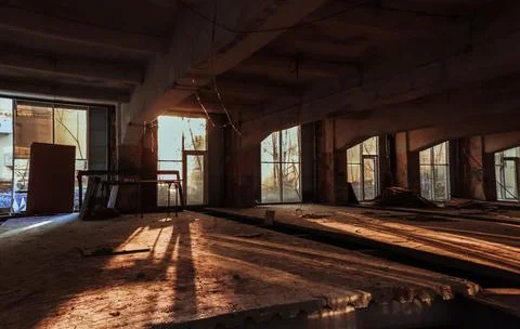 The sun's rays break through the abandoned windows in an empty building. Stock Photos