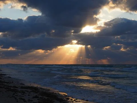 The sun's rays break through the clouds over the sea Stock Photos
