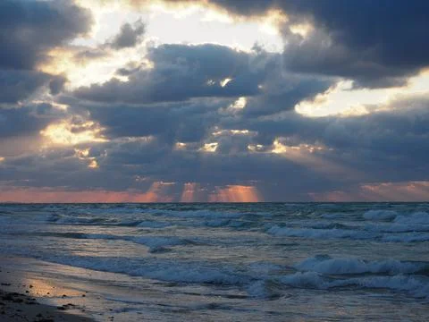 The sun's rays break through the clouds over the sea Stock Photos