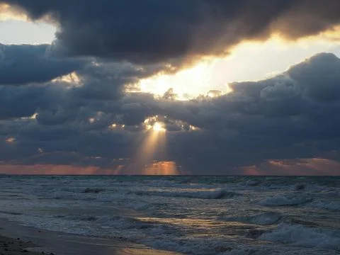The sun's rays break through the clouds over the sea Stock Photos