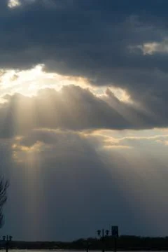 The sun's rays break through the dark clouds... Stock Photos
