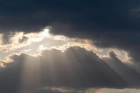 The sun's rays break through the dark clouds Stock Photos