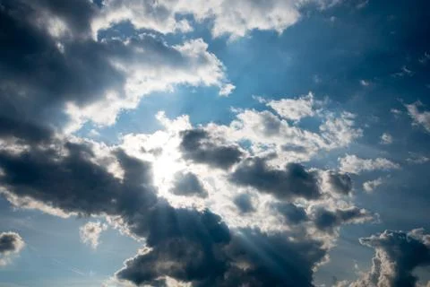 The sun's rays break through the dark, threatening clouds. The concept of fai Stock Photos