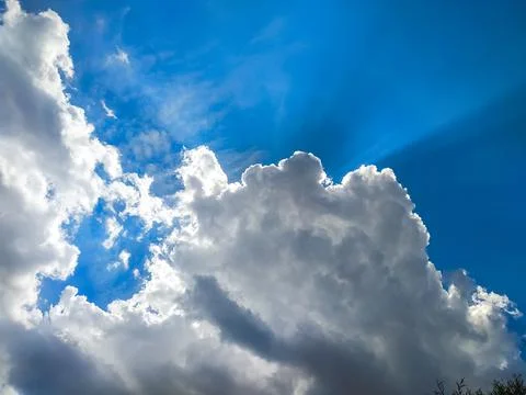 The sun's rays break through the dark clouds in the sky. Beautiful spectacula Stock Photos