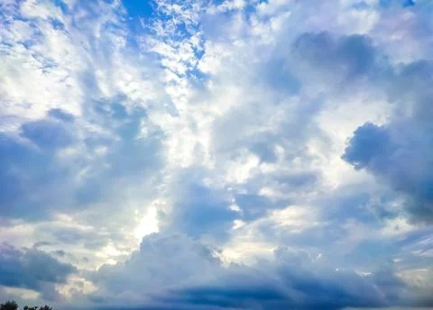 The sun's rays break through the dark clouds in the sky. Beautiful spectacula Stock Photos