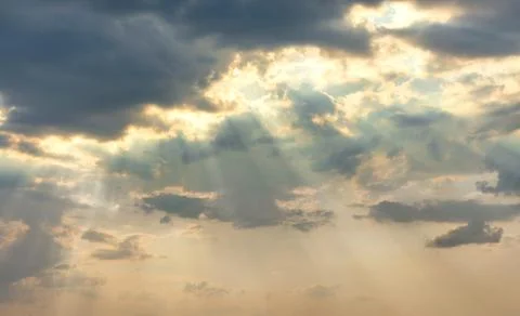 The sun's rays break through dense clouds in even rows. Stock Photos