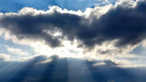 The sun's rays break through a large rain cloud Stock Photos