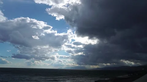 Sun's rays break through storm clouds. Raindrops fall onto camera lens Stock Footage 165639384