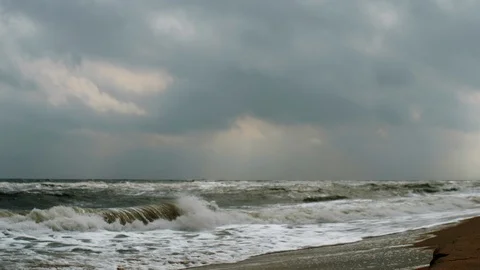 Sun's rays breaking through the clouds on raging sea Video stock 107988372