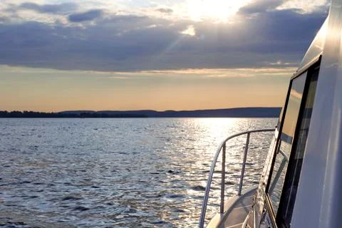 The sun's rays breaking through the clouds. river landscape with boats Stock Photos