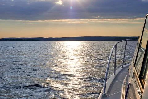 The sun's rays breaking through the clouds. river landscape with boats Stock Photos