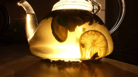 The sun's rays illuminate the transparent teapot. The process of brewing tea Stock Footage 176004166