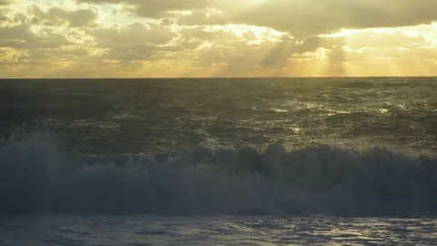 The sun's rays make their way through the clouds to the stormy sea Video stock 82032637