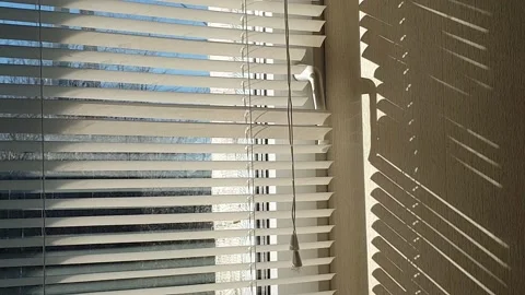 The sun's rays make their way through the blinds in the evening at sunset. 스톡 동영상 143347209