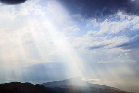 The sun's rays make their way through the clouds. Stock Photos