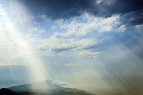 The sun's rays make their way through the clouds. Stock Photos