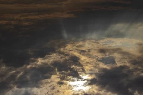 The sun's rays make their way through the clouds in cloudy weather. Stock Photos