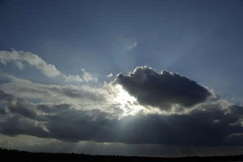 The sun's rays make their way through the black cloud 写真素材