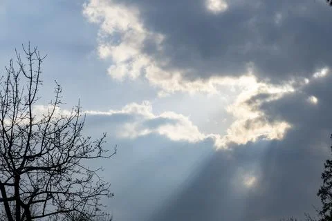 The sun's rays make their way through the dark clouds Stock Photos