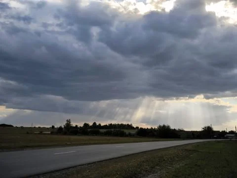 The sun's rays over the highway. The rays of the sun through the clouds. Dr.. 스톡 사진