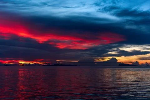 The sun's rays painted the clouds and the sea with scarlet colors Foto stock