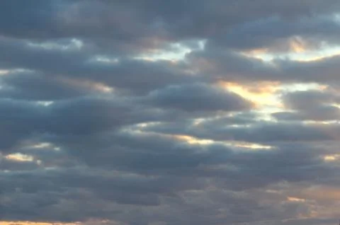 The suns rays pass through the dark clouds. Beautiful dramatic sky at sunset or Stock Photos