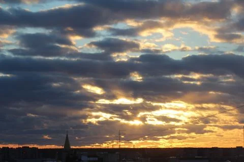 The suns rays pass through the dark clouds. Beautiful dramatic sky at sunset or Stock Photos