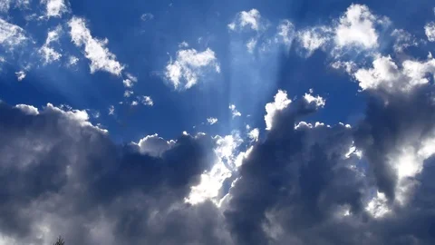 The sun's rays pass through the white clouds against the blue sky. Stock Footage 112665980