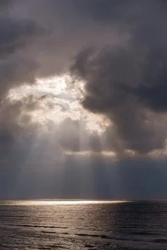 The sun's rays passing through the storm clouds over the sea Foto stock