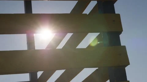 Sun's rays penetrate through the wooden structure. slow motion 180 fps Stock Footage 147088992