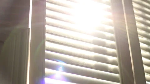The sun's rays shimmer in the blinds close up dolly out shot Stock Footage 202213036