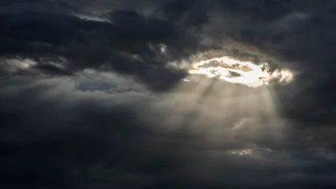 The sun's rays shine through a hole in the continuous cloud cover Stock Photos