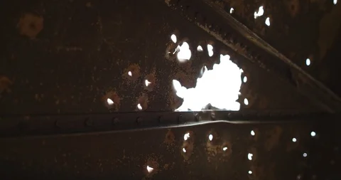 The sun's rays shine through the holes of many bullets. Ver 2 Stock Footage 118546978