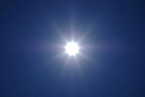 The sun's rays spreading across the cloudless sky. No land image. Stock Photos