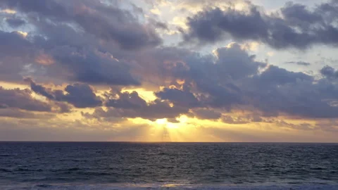 The suns rays through the clouds during a sunset over the pacific ocean Stock Footage 264944156
