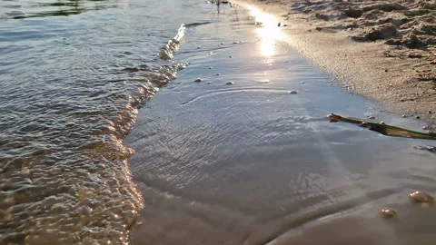 The sun's reflection in the water. Sandy beach with waves. Stock Footage 261149377