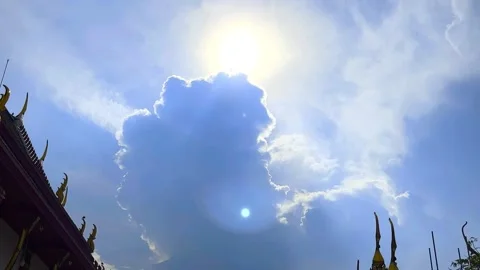 The Sun's Shining Behind Big Cloud and Parts of Roofs of Temple on Blue Sky Stock Footage 330214804